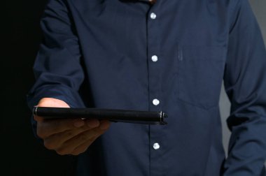 Elinde kara bir kitap tutan bir iş adamı.