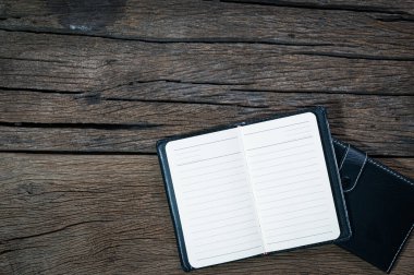 Tahta bir masanın üstüne yerleştirilmiş bir defter.