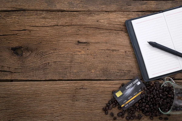 Πιστωτική Κάρτα Notebook Κόκκους Καφέ Τοποθετείται Ένα Ξύλινο Τραπέζι Πάνω — Φωτογραφία Αρχείου