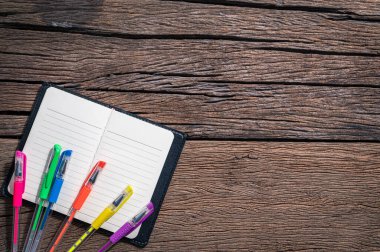 Masa görünümünde çok renkli kalemler ve not defterleri.