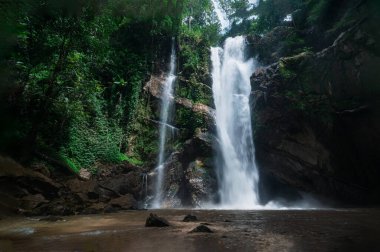 Discover the breathtaking beauty of a waterfall cascading through lush greenery in Chiang Mai. This scenic location offers tranquility and adventure, perfect for nature lovers.