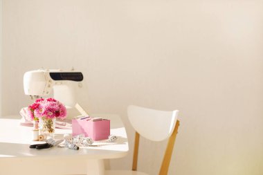 İşyeri dikiş ve iğne işi beyaz mobilya ile parlak bir odada. Bulanıklaştırma efekti ve seçici odak.