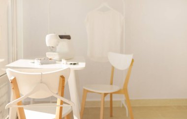 İşyeri dikiş ve iğne işi beyaz mobilya ile parlak bir odada. Bulanıklaştırma efekti ve seçici odak.