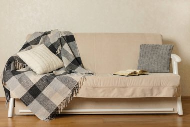 Sonbahar (Kış) kavramı - coziness ve sıcaklık evde. Bej kanepe ekose ve yastıklar oturma odasında. Seçici odak.