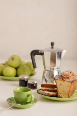 Kahvaltı - kahve ve kek beyaz zemin üzerine yeşil bir kasede. Seçici odak.