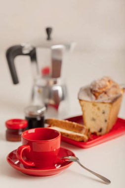 Kahvaltı - kahve ve kek beyaz zemin üzerine kırmızı bir kabın içinde. Seçici odak.