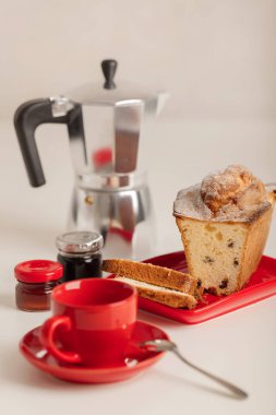 Kahvaltı - kahve ve kek beyaz zemin üzerine kırmızı bir kabın içinde. Seçici odak.