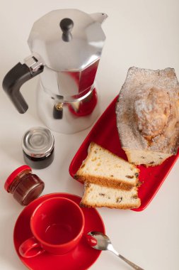 Kahvaltı - kahve ve kek beyaz zemin üzerine kırmızı bir kabın içinde. Seçici odak.