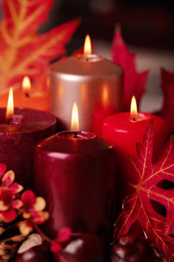 Sonbahar natürmort - mumlar, yaprakları ve yastıklar arka plan üzerinde konisi. Seçici odak.