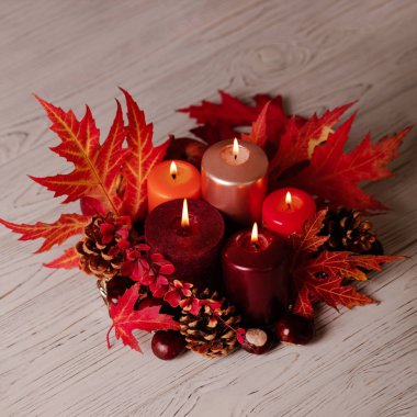 Sonbahar natürmort - mumlar, yaprakları ve yastıklar arka plan üzerinde konisi. Seçici odak.