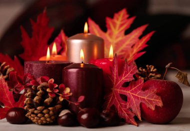 Sonbahar natürmort - mumlar, yaprakları ve yastıklar arka plan üzerinde konisi. Seçici odak.