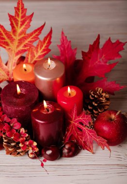 Sonbahar natürmort - mumlar, yaprakları ve yastıklar arka plan üzerinde konisi. Seçici odak.