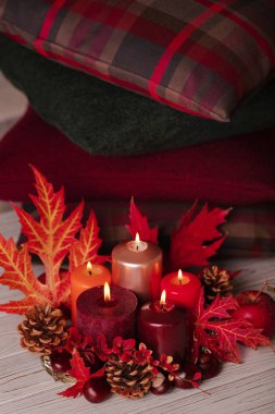 Sonbahar natürmort - mumlar, yaprakları ve yastıklar arka plan üzerinde konisi. Seçici odak.