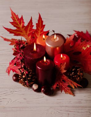 Sonbahar natürmort - mumlar, yaprakları ve yastıklar arka plan üzerinde konisi. Seçici odak.