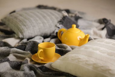 Ev rahatlık ve sıcaklık sonbahar zamanında. Şal, Örgü yastık, çay ve sonbahar akçaağaç yaprakları gri. Seçici odak.