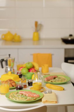 Kahvaltı zamanı. Omlet Yeşiller ve sosis. Kruvasan ve portakal suyu, reçel. Krema veya süt ile kahve. Meyve - muz, kırmızı ve yeşil elma. Seçici odak.