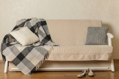 Sonbahar (Kış) kavramı - coziness ve sıcaklık evde. Bej kanepe ekose ve yastıklar oturma odasında. Seçici odak.