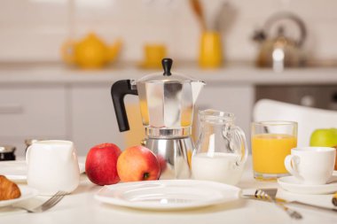 Kahvaltı zamanı. Kruvasan ve portakal suyu, reçel ve bal. Krema veya süt ile kahve. Meyve - muz, kırmızı ve yeşil elma. Beyaz bir masaya Servis Kahvaltı. 