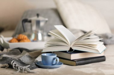 Yatakta kahvaltı. Beyaz bir tepsi üzerinde bir kahve makinesi, mavi kahve ve kruvasan işte. Seçici odak.