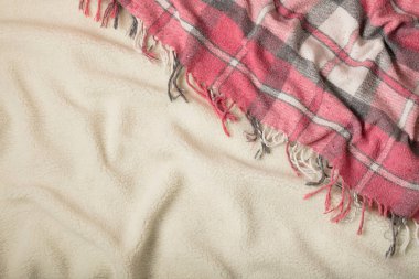 Kış zamanı. Rahat, sıcak ve pembe bir battaniye ve bir fincan kahve ve kruvasan yatakta. Seçici odak.