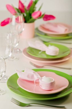 Mutlu Paskalyalar. Dekor ve Paskalya tablonun tablo ayarını pembe laleler ve yemekleri pembe ve yeşil renk ile bir vazo var. Seçici odak.