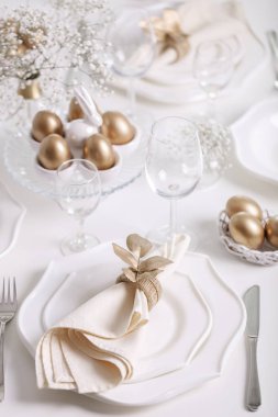 Mutlu Paskalyalar! Altın dekor ve Tablo ayarı Paskalya tablo ile beyaz renk beyaz yemekleri. Seçici odak.