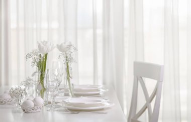 Mutlu Paskalyalar! Beyaz Laleler ve beyaz renk yemekler Paskalya tabloyla dekor ve Tablo ayarı. Seçici odak.