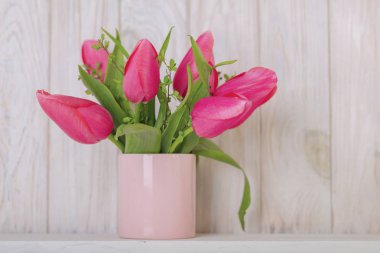 Mutlu Paskalyalar. Dekor ve Paskalya tablonun tablo ayarını pembe laleler ve yemekleri pembe ve yeşil renk ile bir vazo var. Seçici odak.