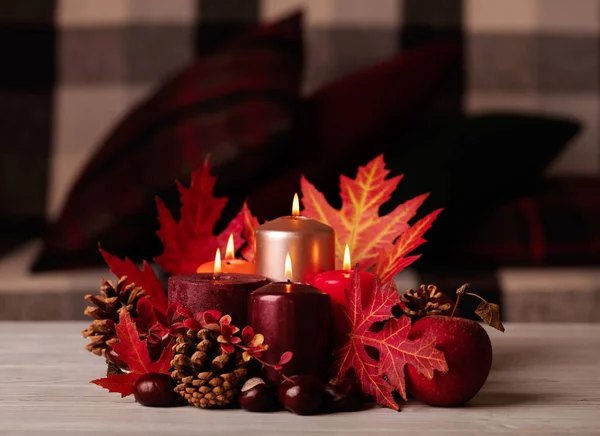 Sonbahar natürmort - arka planda mumlar, yapraklar ve koniler 