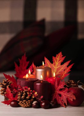 Sonbahar natürmort - arka planda mumlar, yapraklar ve koniler 