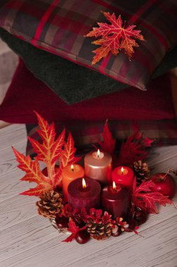 Sonbahar natürmort - arka planda mumlar, yapraklar ve koniler 