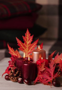 Sonbahar natürmort - arka planda mumlar, yapraklar ve koniler 