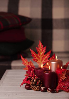 Sonbahar natürmort - arka planda mumlar, yapraklar ve koniler 