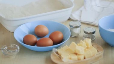 Pasta hamuru yoğurmak için yumurta kıran kadınların yakın çekimi..
