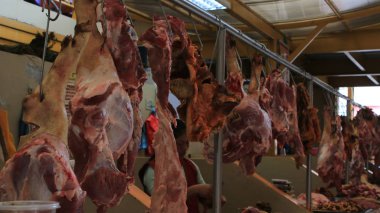 Domuz parçalara ayrılmış ve Latin Amerika pazarında açık havada asılı