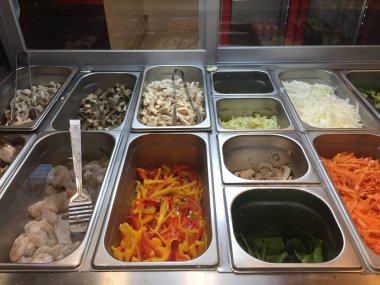 Taze kesilmiş sebze ve et ile yemek tepsileri bir Asya restoranda pişirmek