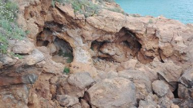 Mağaraların ve yüzlerin görüleceği kayalık bir kayalığın görünümü