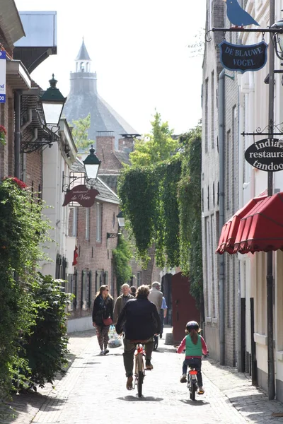 Den Bosch, Netherlands, 13-9-2010: People on a bike and walking through the dutch city Den Bosch on a summer day — Stock Photo, Image