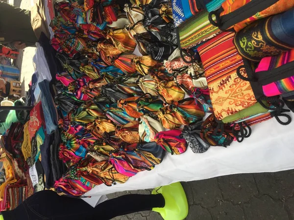 A market stand at the famous market in Otavalo with multicolored bags and typical andean, south american patterns