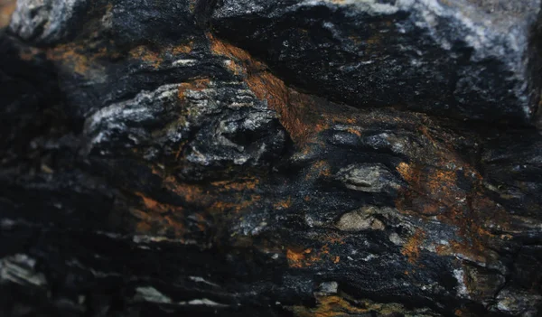 Ein bläulich schwarzer Stein mit viel Rost in den Taschen — Stockfoto