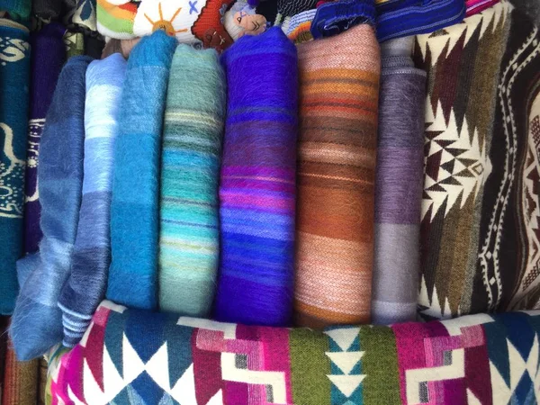 Bunte kleidung, seile, teppiche zum verkauf auf einem markt in ecuador — Stockfoto