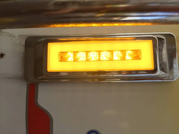 Um grande indicador de luz piscando em uma cor laranja em um fundo branco — Fotografia de Stock