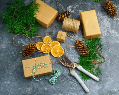 Noel hediyeleri koniler ve beton zemin üzerine Kuru portakal dilimleri ile dekore edilmiş