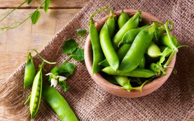 Tuval Jüt kumaş üzerine hafif ahşap kase taze çiğ yeşil bezelye