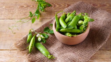 Tuval Jüt kumaş üzerine hafif ahşap kase taze çiğ yeşil bezelye