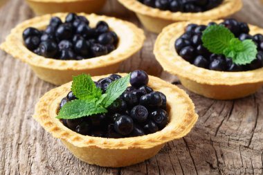 mini turta blueberry vintage ahşap zemin üzerine nane yaprakları ile