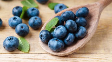 Tahta kaşık ile yeşil nane taze çekilmiş yaban mersini görünümü Kapat bırakır