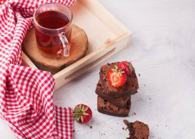 Ev yapımı çikolatalı brownie adet taze çilek ile sıcak siyah çay servisi