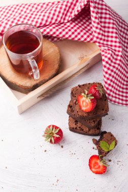 Ev yapımı çikolatalı brownie adet taze çilek ile sıcak siyah çay servisi