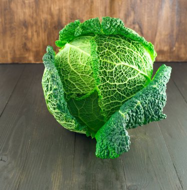 Kahverengi ahşap zemin üzerinde ham savoy lahana